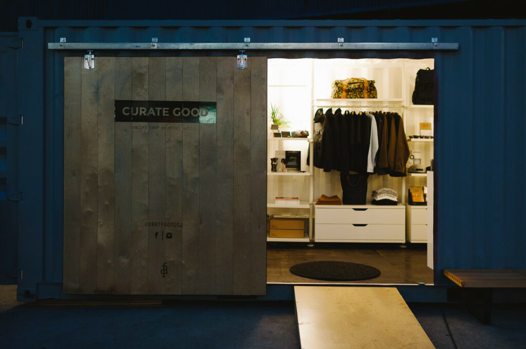 Container pop-up shop lit up at night Shipping container pop-up shop at night, its interior lighting showing the products inside from the street
