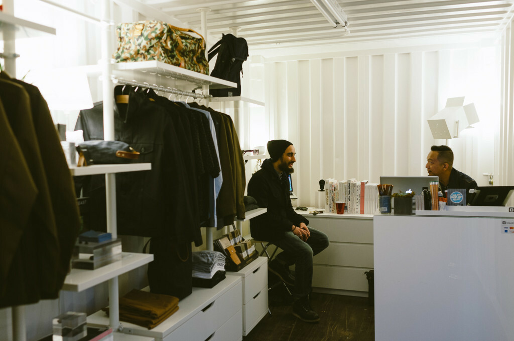 Inside a shipping container pop-up shop Inside a shipping container pop-up shop showing the checkout till and products displayed on the wall