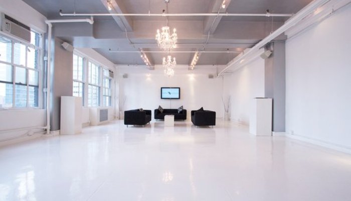 Showroom intimiste à Paris avec canapés et murs blancs, touche industrielle
