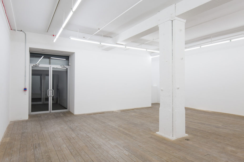 Minimal white-box shop interior in Chelsea arts district with open layout and clean finishes