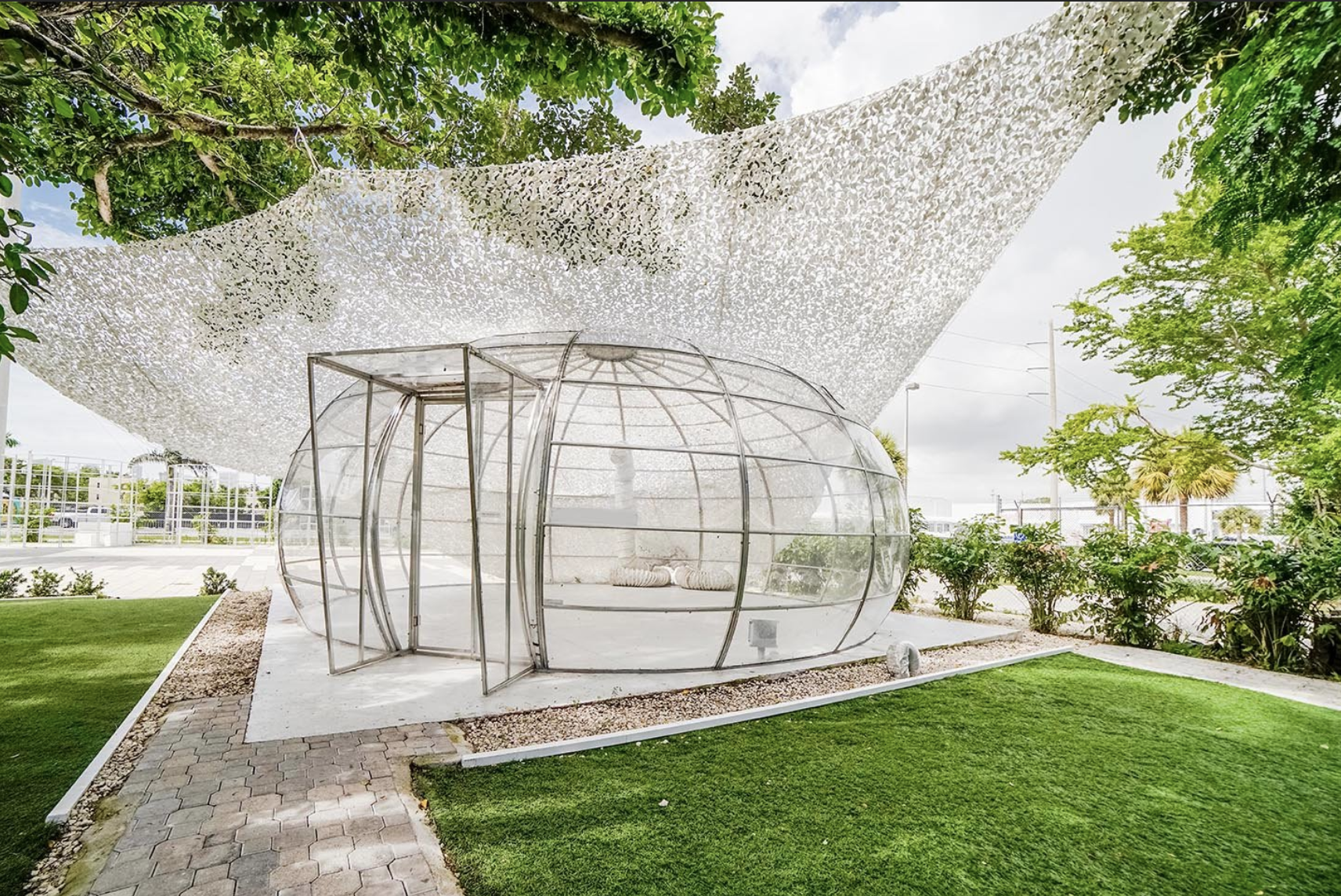 A transparent pod event space in a landscaped Miami setting