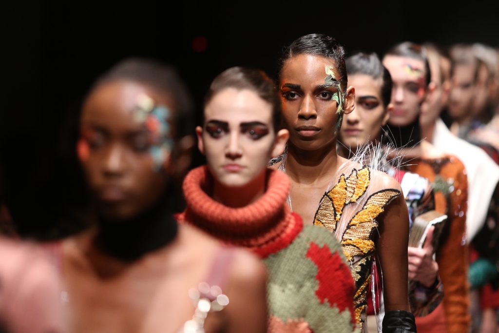 Gros plan sur les visages de mannequins défilant sur le podium à la Fashion Week de Paris