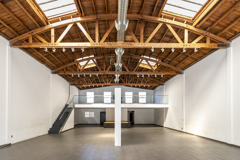 Vaste showroom d'exception à Paris avec une grande charpente en bois et un immense espace ouvert