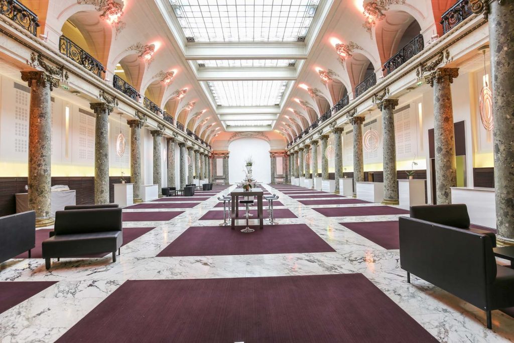Showroom éphémère somptueux, moquette violette, miroirs dorés et lustres en cristal, aménagé pour un lancement de marque de luxe.