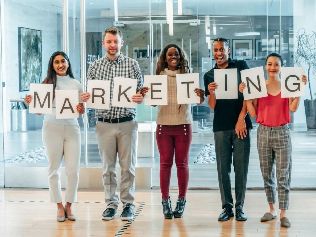 People holding cardboard letters of marketing