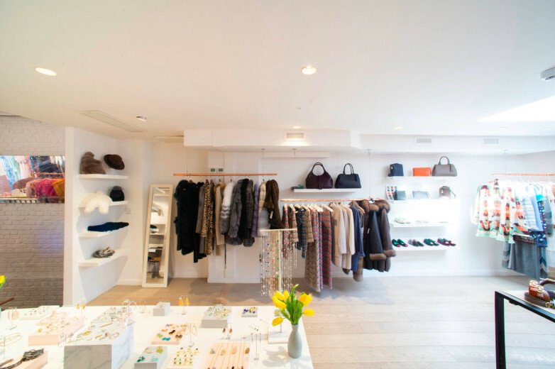 Boutique éphémère et showroom lumineux en sous-sol, avec des vêtements exposés.
